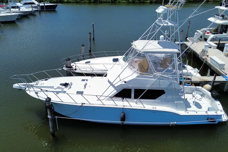 Slide: The Image of 1990 Hatteras 45 Convertible yacht docked in a marina, side view. - 18