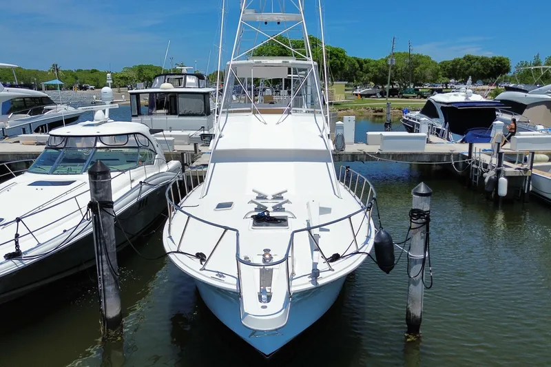 Slide: The Image of 1990 Hatteras 45 Convertible yacht docked at marina under clear blue sky. - 13