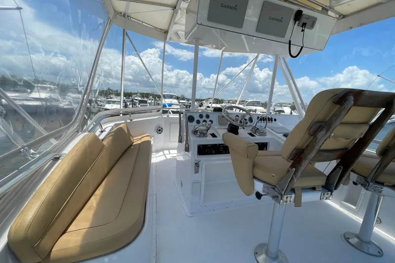 Slide: The Image of 1990 Hatteras 45 Convertible yacht cockpit with beige seating and navigation equipment. - 32
