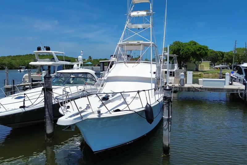 Slide: The Image of 1990 Hatteras 45 Convertible yacht docked at marina under clear blue sky. - 16