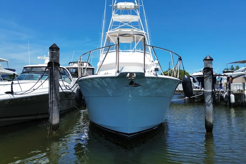 Slide: The Image of 1990 Hatteras 45 Convertible yacht docked at marina under clear blue sky. - 9