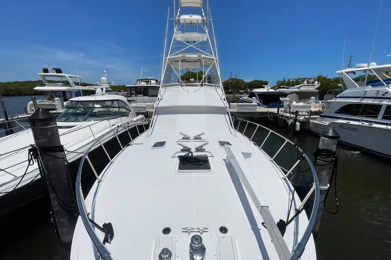 Slide: The Image of 1990 Hatteras 45 Convertible yacht docked at marina, surrounded by other boats. - 45