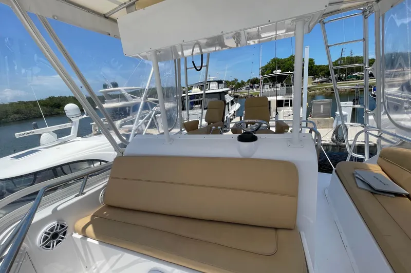 Slide: The Image of 1990 Hatteras 45 Convertible yacht interior with beige seating and marina view. - 39