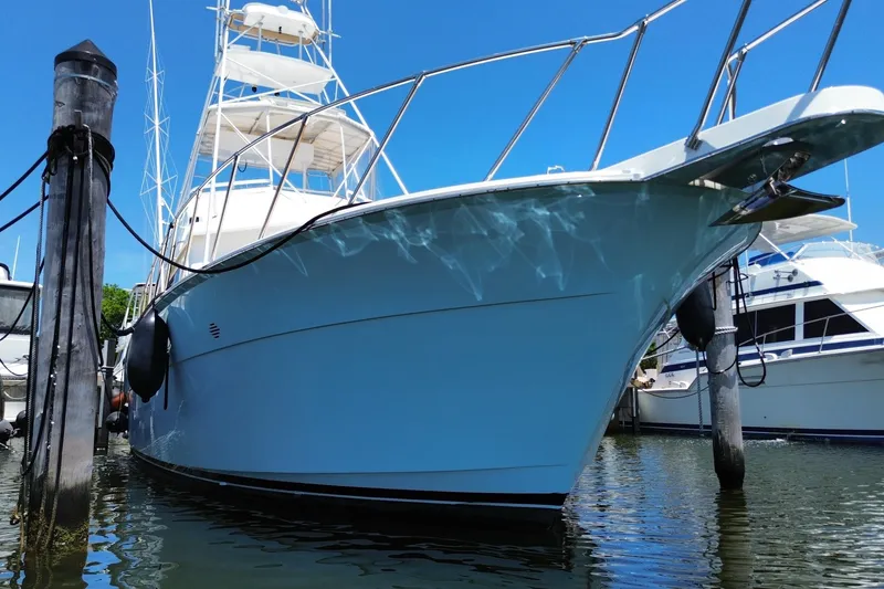 Slide: The Image of 1990 Hatteras 45 Convertible yacht docked in marina, reflecting on calm water. - 1