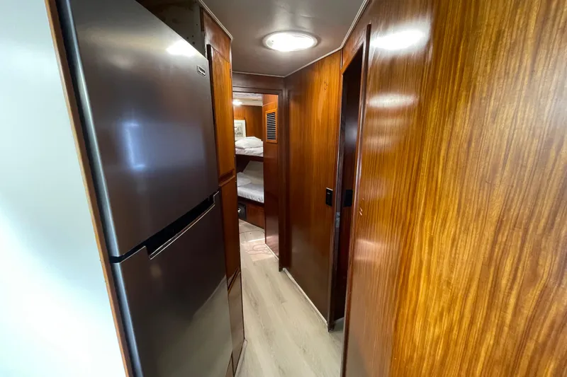 Slide: The Image of Interior hallway of 1990 Hatteras 45 Convertible yacht with wood paneling and modern refrigerator. - 58