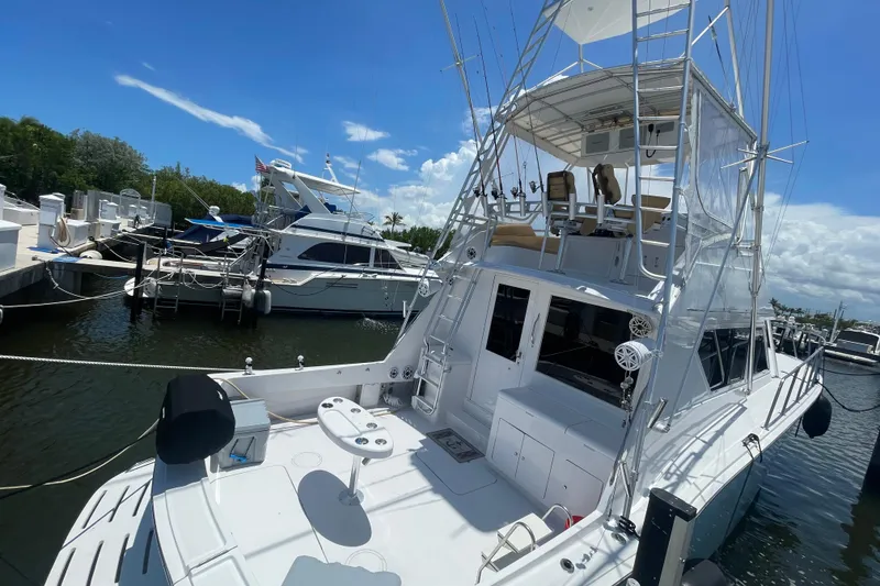 Slide: The Image of 1990 Hatteras 45 Convertible yacht docked at marina under clear blue sky. - 28