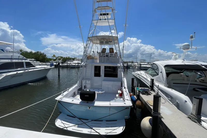 Slide: The Image of 1990 Hatteras 45 Convertible yacht docked at marina under clear blue sky. - 25