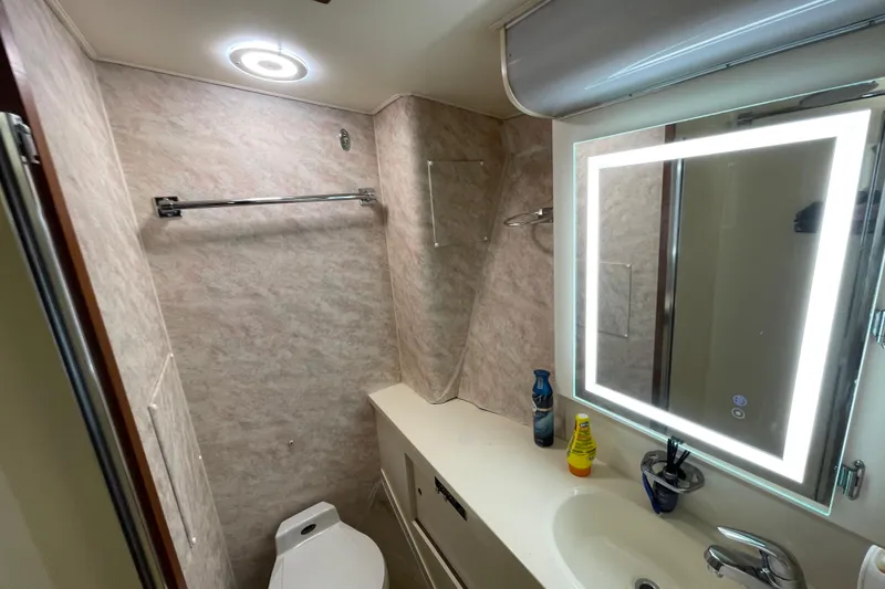 Slide: The Image of Bathroom interior of 1990 Hatteras 45 Convertible yacht with illuminated mirror and modern fixtures. - 65