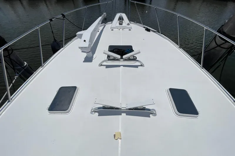 Slide: The Image of Bow view of 1990 Hatteras 45 Convertible yacht, featuring deck hatches and railings. - 42