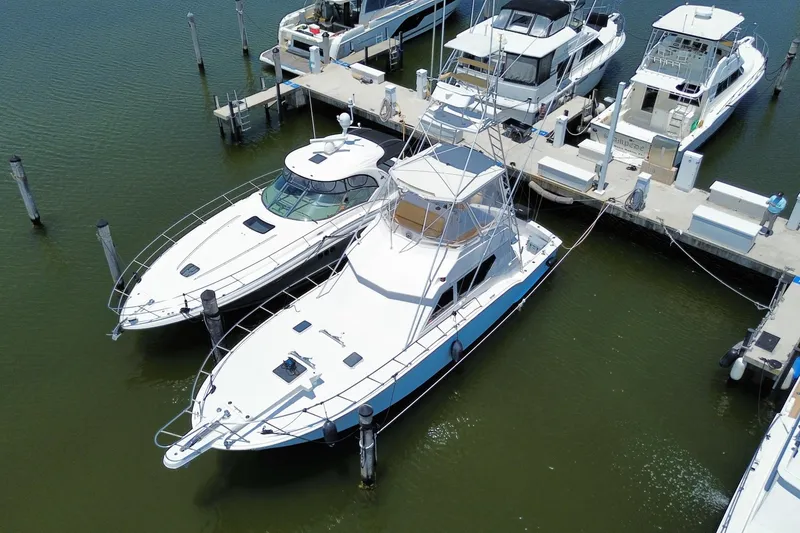 Slide: The Image of 1990 Hatteras 45 Convertible yacht docked among other boats in a marina. - 4