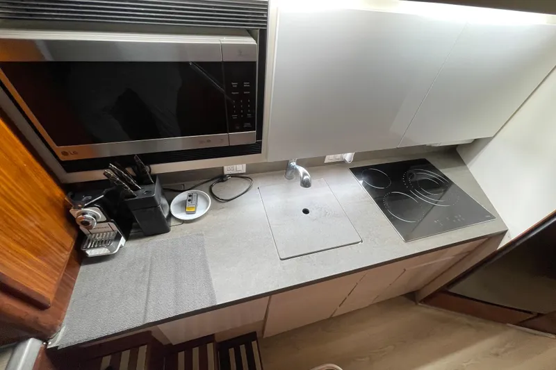 Slide: The Image of Compact kitchen in a 1990 Hatteras 45 Convertible yacht with modern appliances. - 56