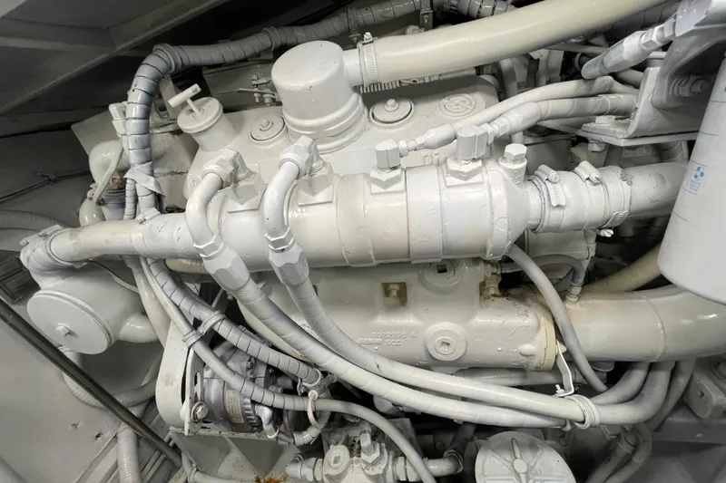 Slide: The Image of Engine components of a 1990 Hatteras 45 Convertible boat, showcasing intricate piping and machinery. - 80