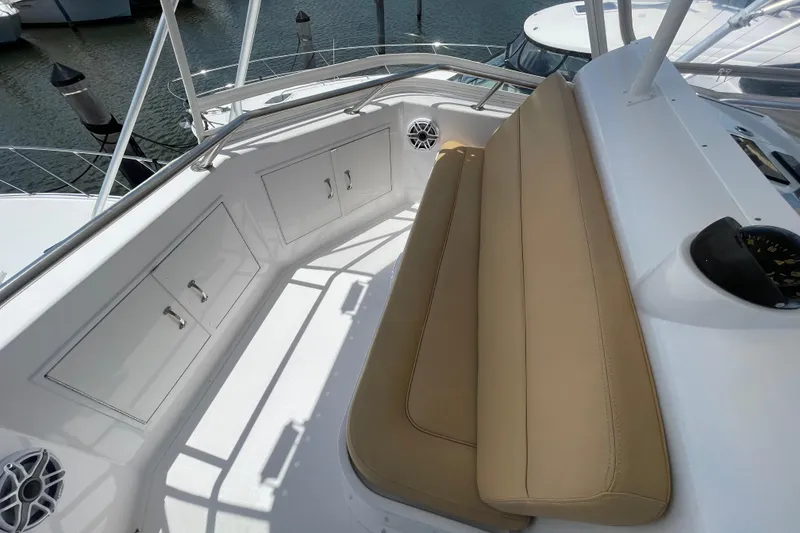 Slide: The Image of 1990 Hatteras 45 Convertible yacht cockpit with beige seating and storage cabinets. - 38
