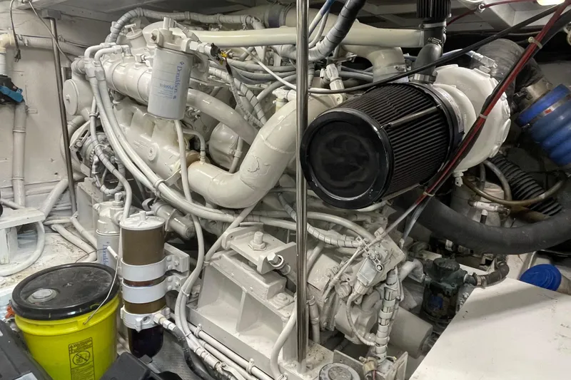Slide: The Image of Engine room of a 1990 Hatteras 45 Convertible yacht, showcasing complex machinery. - 77
