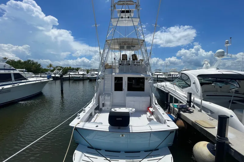 Slide: The Image of 1990 Hatteras 45 Convertible yacht docked at marina under blue sky. - 51