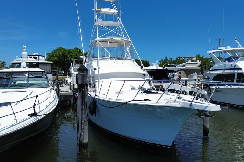 Slide: The Image of 1990 Hatteras 45 Convertible yacht docked at marina under clear blue sky. - 5