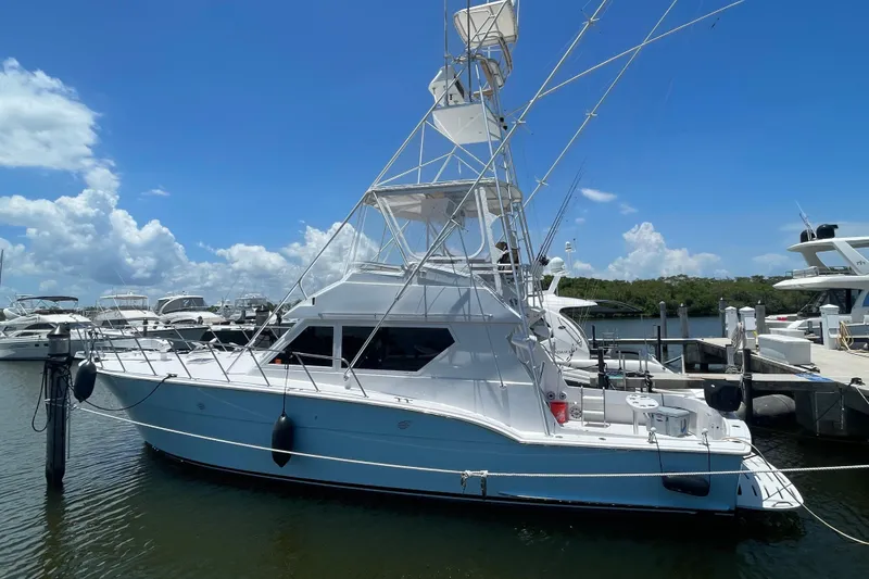 Slide: The Image of 1990 Hatteras 45 Convertible yacht docked at marina under clear blue sky. - 26
