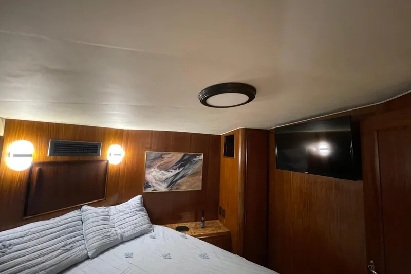 Slide: The Image of Interior cabin of 1990 Hatteras 45 Convertible yacht with bed, TV, and wall art. - 66