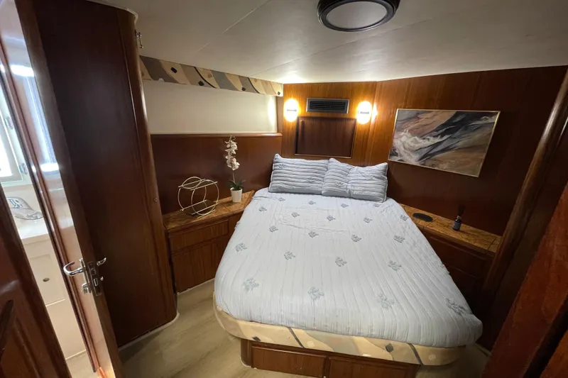 Slide: The Image of Cozy bedroom interior of 1990 Hatteras 45 Convertible yacht with elegant wood paneling. - 60