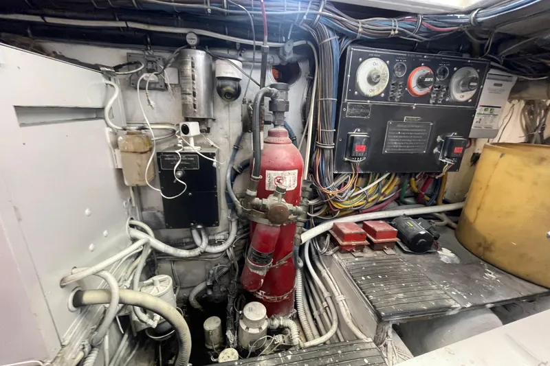 Slide: The Image of Engine room of a 1990 Hatteras 45 Convertible boat, featuring control panels and wiring. - 82