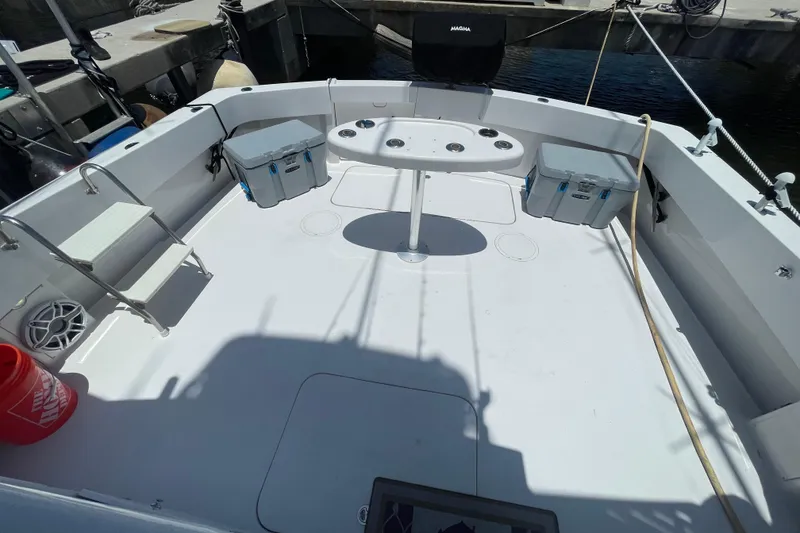 Slide: The Image of 1990 Hatteras 45 Convertible boat deck with fishing setup and storage boxes. - 30
