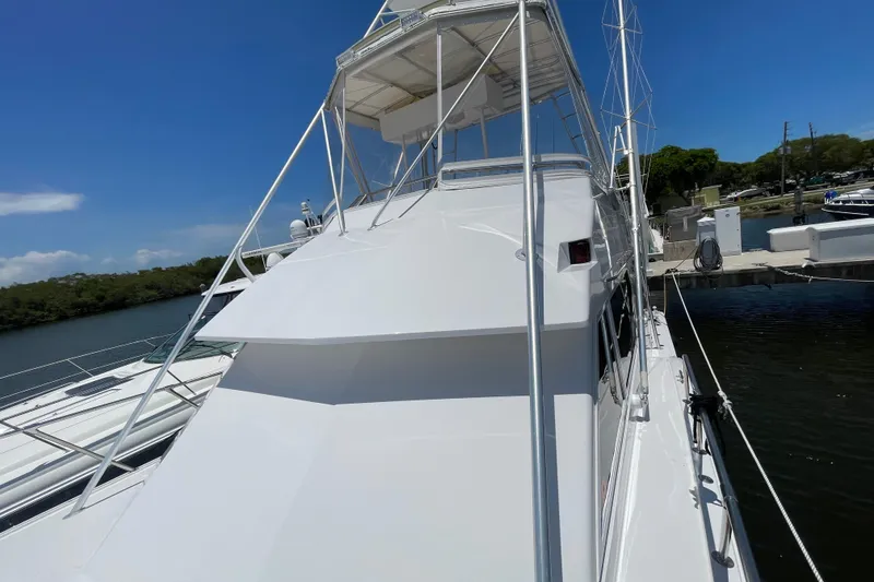 Slide: The Image of 1990 Hatteras 45 Convertible yacht docked under clear blue sky. - 50