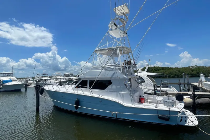 Slide: The Image of 1990 Hatteras 45 Convertible yacht docked at marina under clear blue sky. - 27