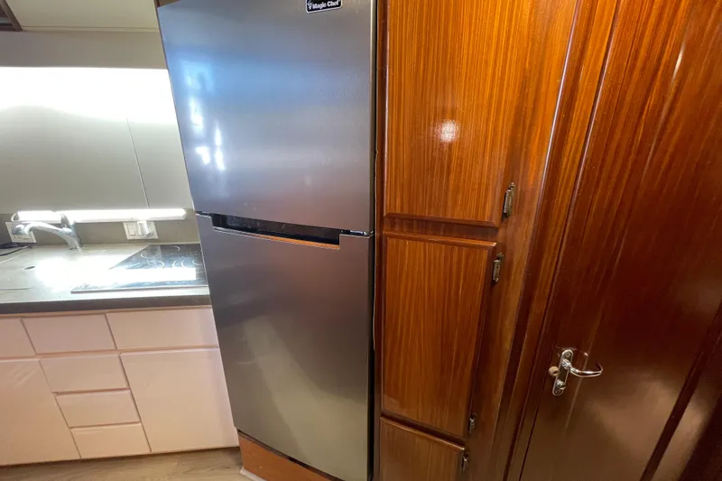 Slide: The Image of Kitchen area of a 1990 Hatteras 45 Convertible yacht with stainless steel fridge. - 67