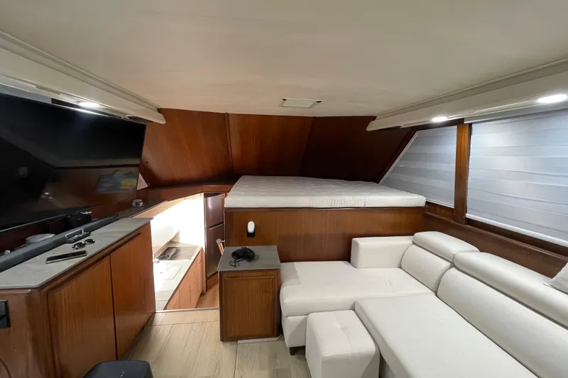 Slide: The Image of Interior of 1990 Hatteras 45 Convertible yacht with modern furnishings and wood paneling. - 54