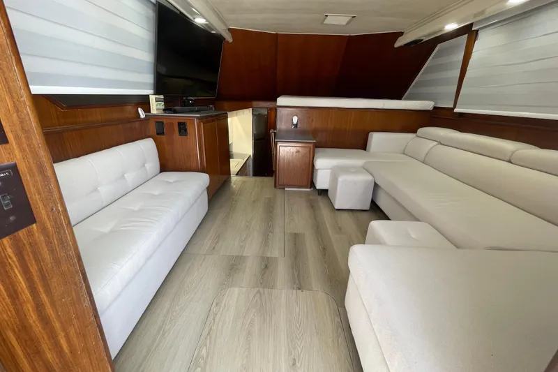Slide: The Image of Luxurious interior of 1990 Hatteras 45 Convertible yacht with modern furnishings and wood accents. - 76