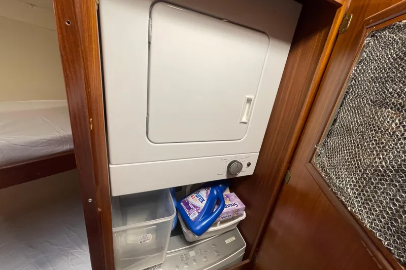 Slide: The Image of Laundry area inside a 1990 Hatteras 45 Convertible yacht with washer and storage. - 75