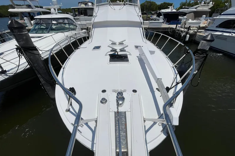 Slide: The Image of Bow view of 1990 Hatteras 45 Convertible yacht docked at marina. - 46