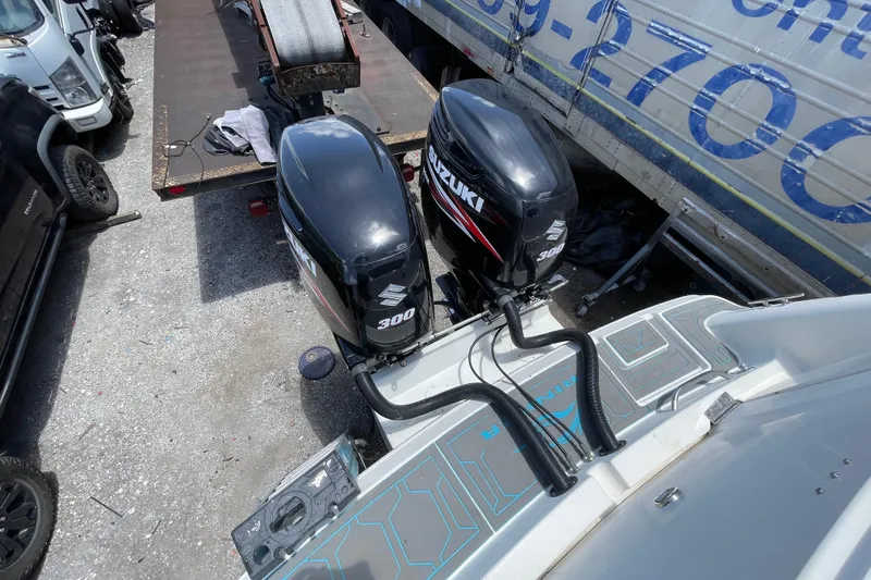 Slide: The Image of 2000 Rinker 280 Express Cruiser with dual Suzuki 300 outboard motors in a boatyard. - 31