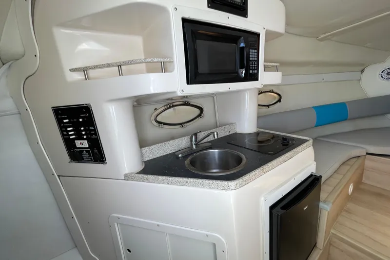 Slide: The Image of Interior of 2000 Rinker 280 Express Cruiser with kitchenette, microwave, and seating area. - 42