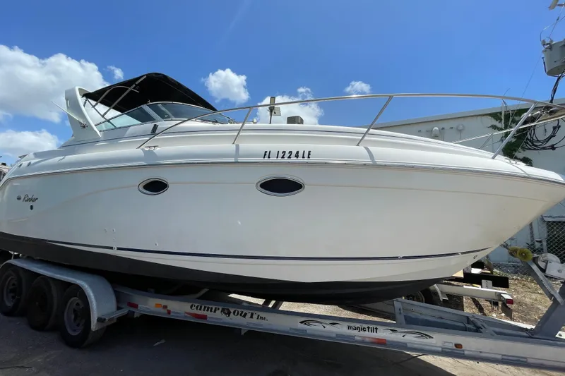 Slide: The Image of 2000 Rinker 280 Express Cruiser on trailer under blue sky. - 24