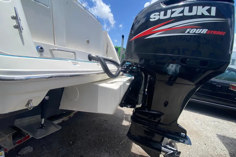 Slide: The Image of 2000 Rinker 280 Express Cruiser with Suzuki Four Stroke outboard motor, docked under blue sky. - 55
