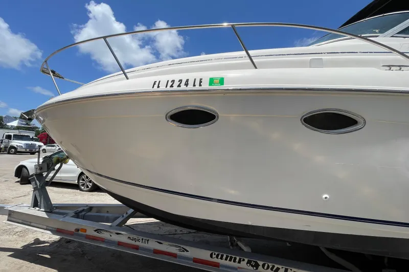 Slide: The Image of 2000 Rinker 280 Express Cruiser on trailer, side view with registration number visible. - 21