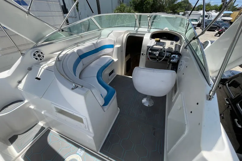 Slide: The Image of 2000 Rinker 280 Express Cruiser interior with white and blue seating, steering wheel, and dashboard. - 34