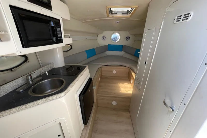 Slide: The Image of Interior of 2000 Rinker 280 Express Cruiser with kitchenette and seating area. - 41