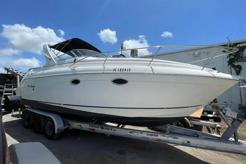 Slide: The Image of 2000 Rinker 280 Express Cruiser on trailer under blue sky. - 9