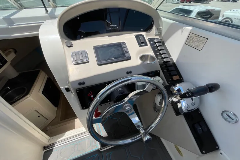 Slide: The Image of Cockpit of 2000 Rinker 280 Express Cruiser with steering wheel and control panel. - 38