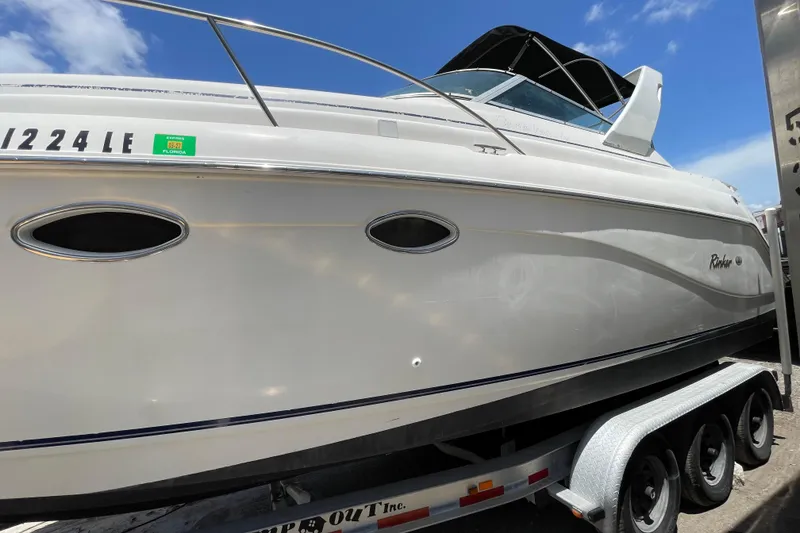 Slide: The Image of 2000 Rinker 280 Express Cruiser on trailer under clear blue sky. - 23