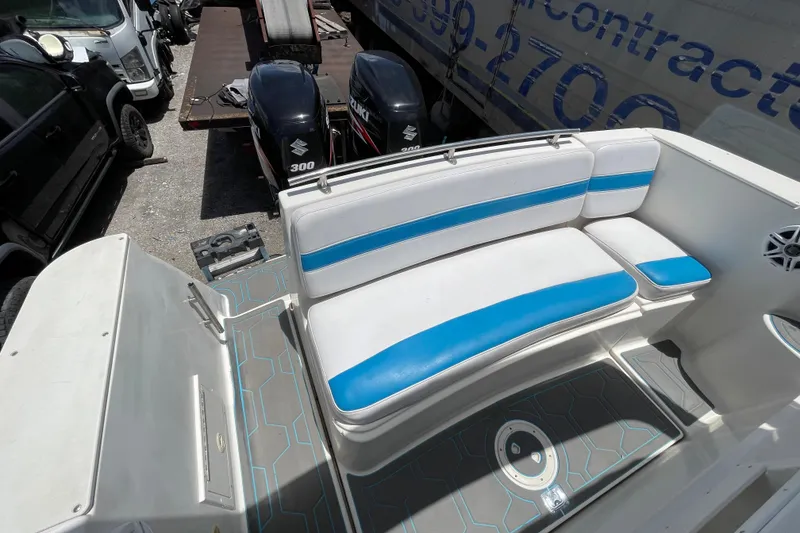 Slide: The Image of 2000 Rinker 280 Express Cruiser interior with blue and white seating, docked near Suzuki engines. - 33