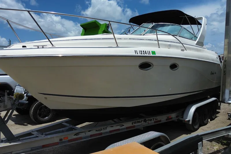 Slide: The Image of 2000 Rinker 280 Express Cruiser on trailer under blue sky. - 4
