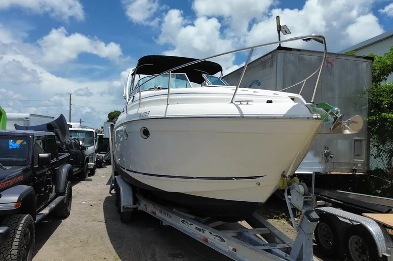 Slide: The Image of 2000 Rinker 280 Express Cruiser on trailer under a bright blue sky. - 17