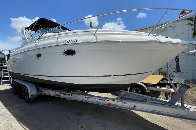Slide: The Image of 2000 Rinker 280 Express Cruiser on trailer under clear blue sky. - 1