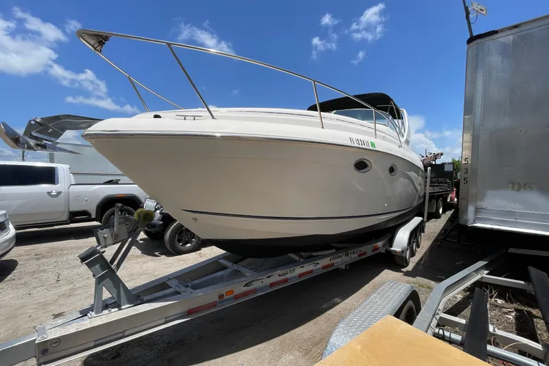 Slide: The Image of 2000 Rinker 280 Express Cruiser on trailer under clear blue sky. - 7