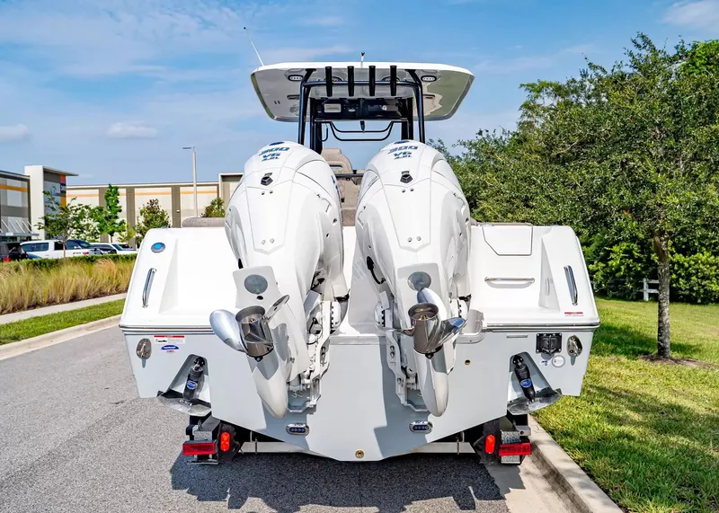 Slide: The Image of Rear view of a Sea Hunt Ultra 285 SE with twin outboard engines, parked on a street. - 3