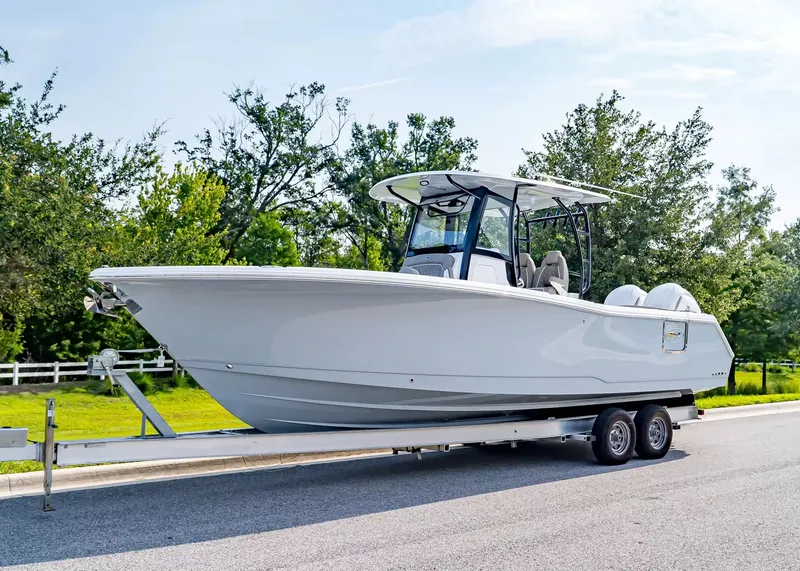 The Image of A 2027 Sea Hunt Ultra 285 SE boat on a trailer, surrounded by trees. - 1