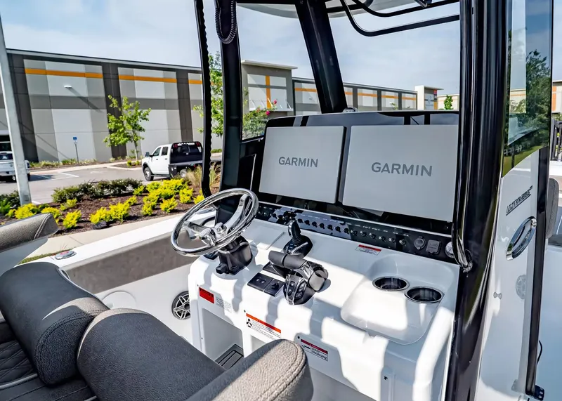 Slide: The Image of The image shows the helm of a Sea Hunt Ultra 285 SE boat with dual Garmin screens. - 15